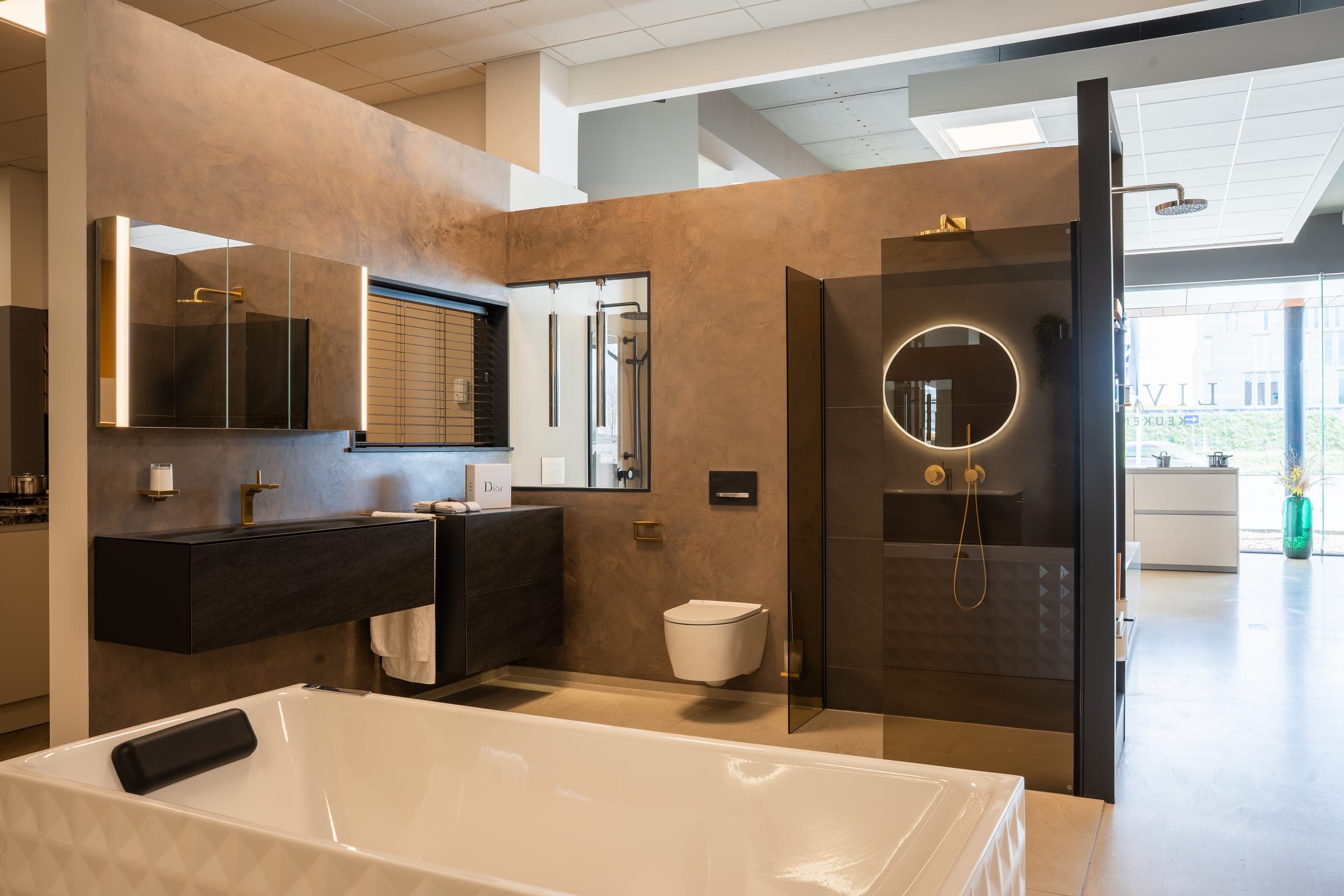 Showroomopstelling badkamer met terracotta wandafwerking, vrijstaand bad en inloopdouche