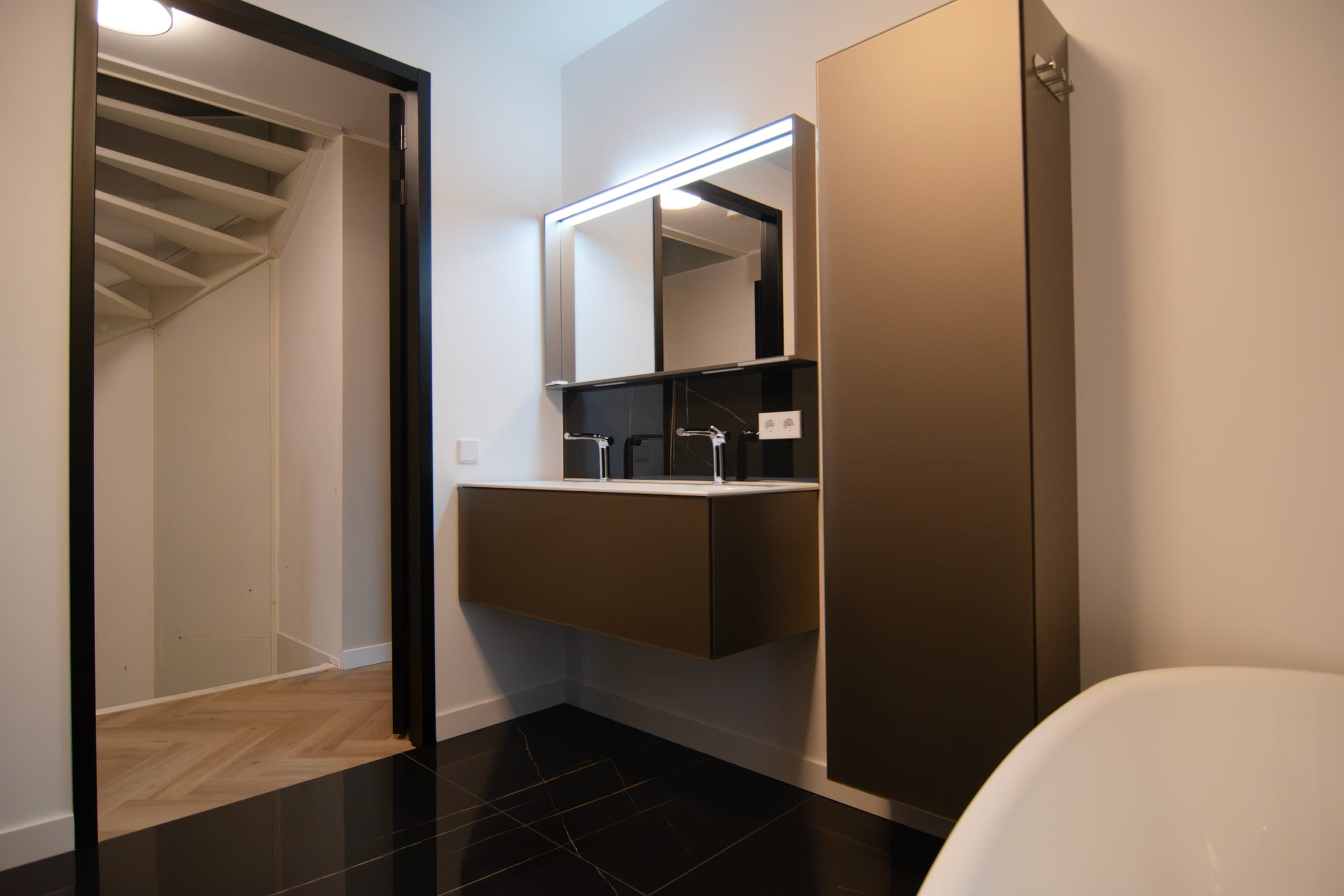 Doorkijk vanuit slaapkamer naar badkamer met vrijstaand bad