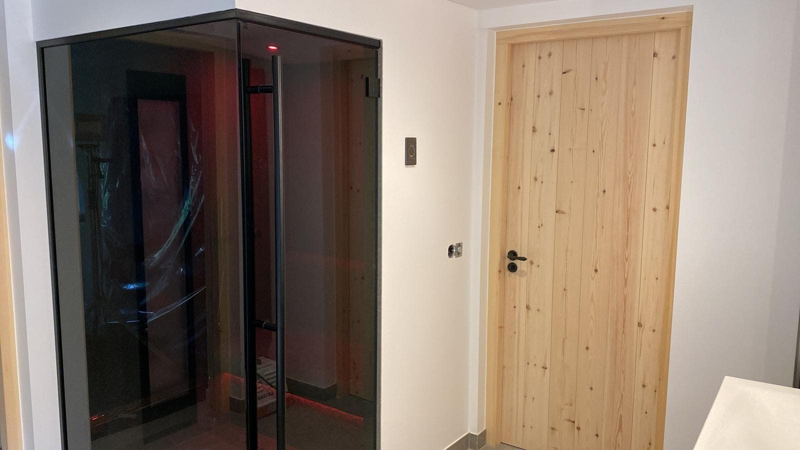 Glazen wellness-cabine naast houten deur — Domburg